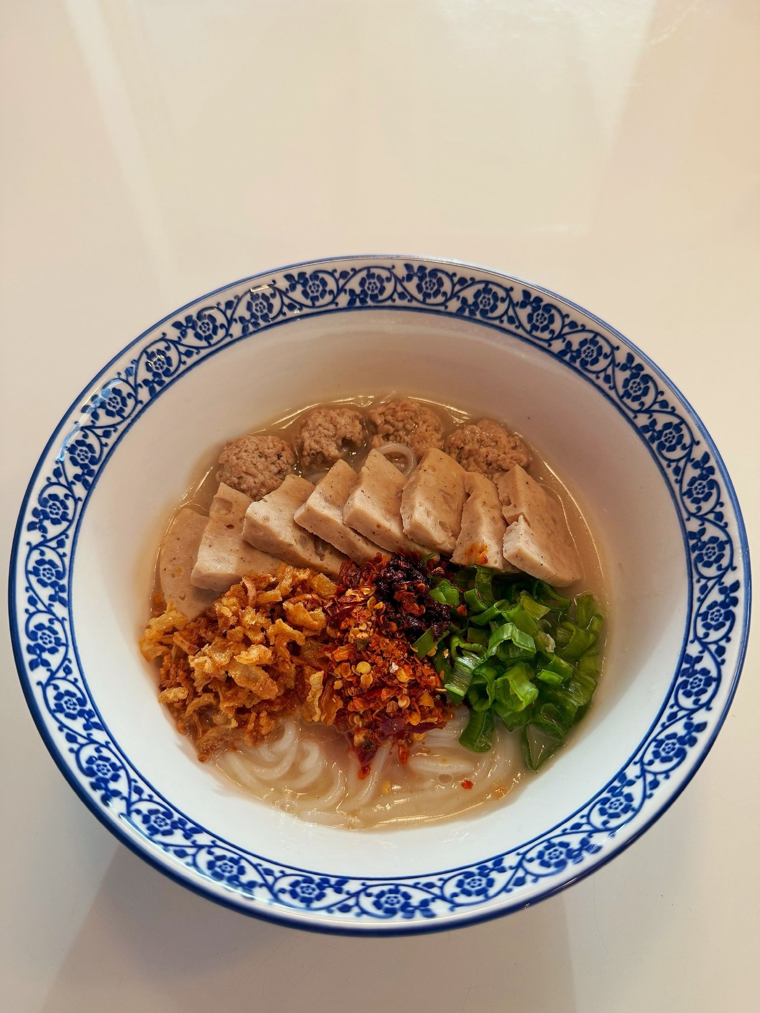 A bright Thai soup with herbs and seafood served in a metal pot on Koh Samet.